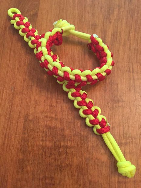 a yellow and red bracelet on top of a wooden table