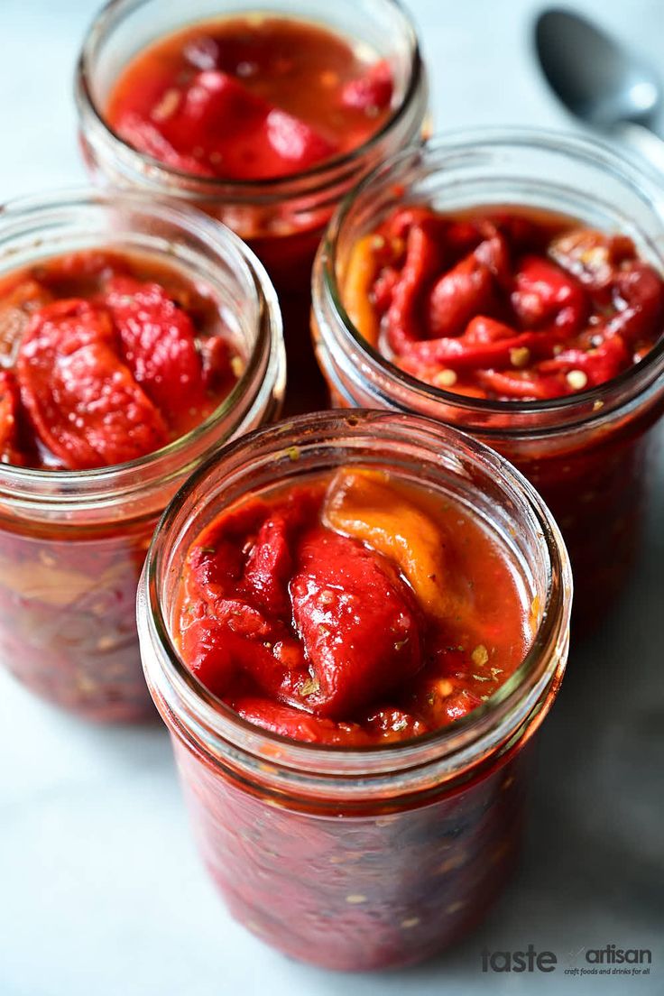 four jars filled with food sitting on top of a table