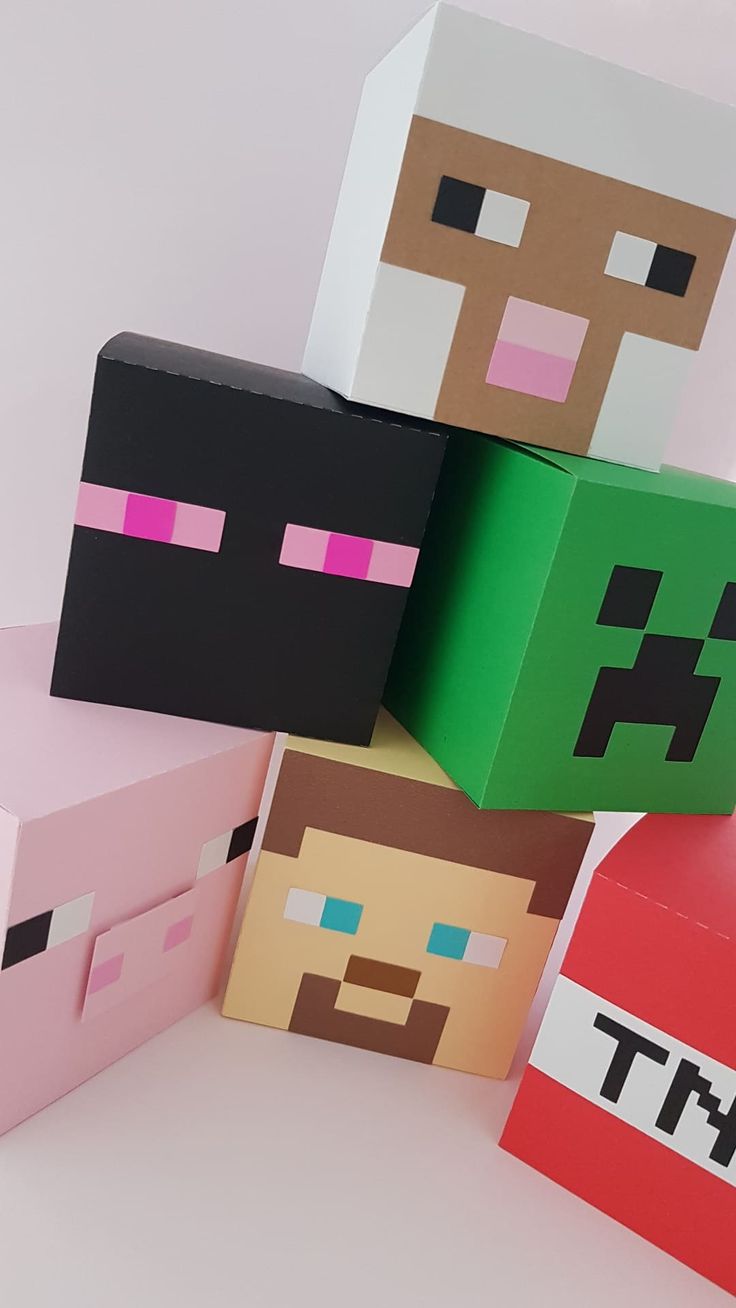 some paper toys that look like minecraft characters are stacked on top of each other