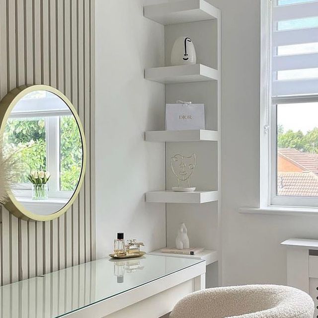 a white desk and chair in a room with a mirror on the wall above it