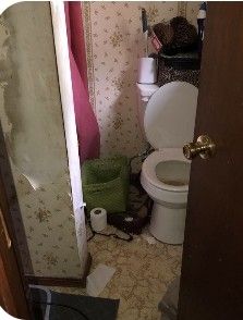 a bathroom with a toilet and pink shower curtain