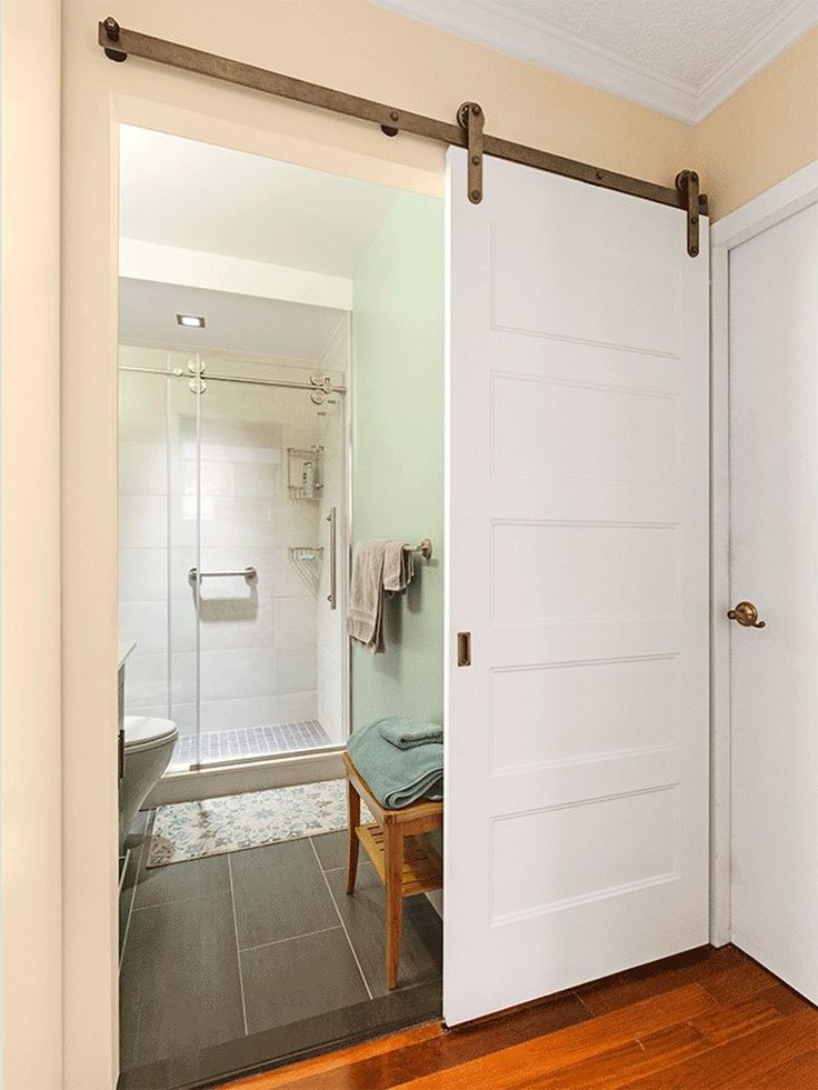 an open door leading to a bathroom with a walk in shower