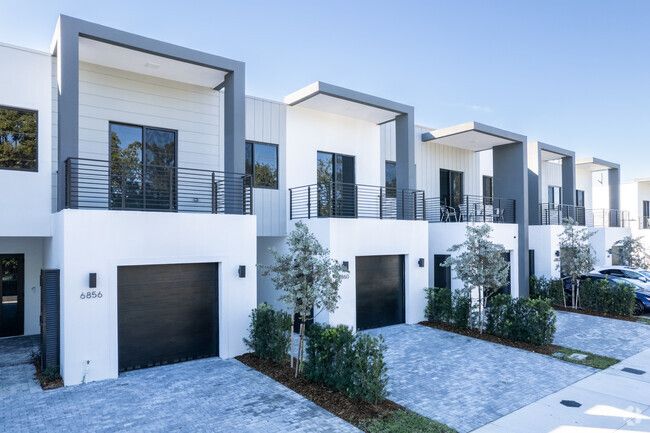 a row of townhouses with garages and trees