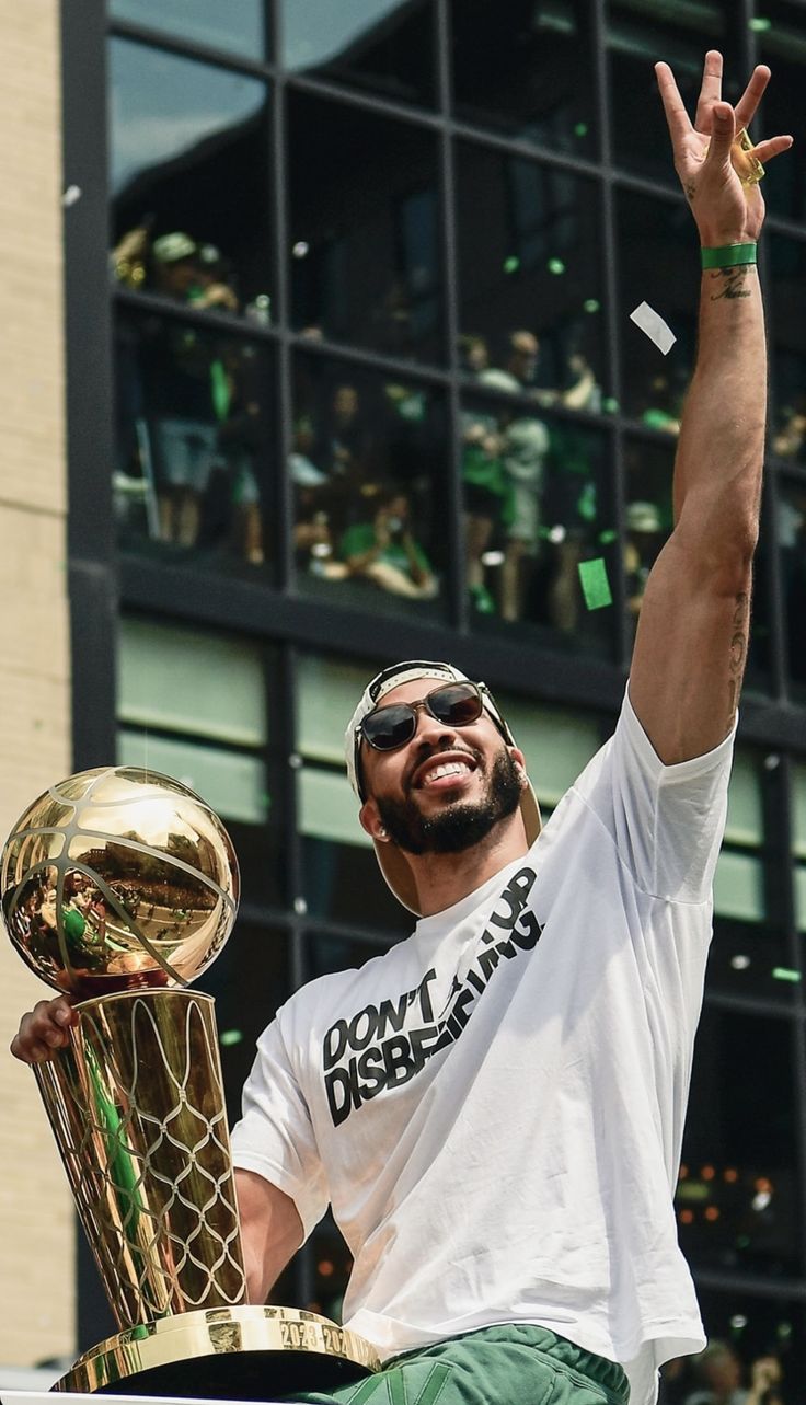 a man holding up a trophy in the air