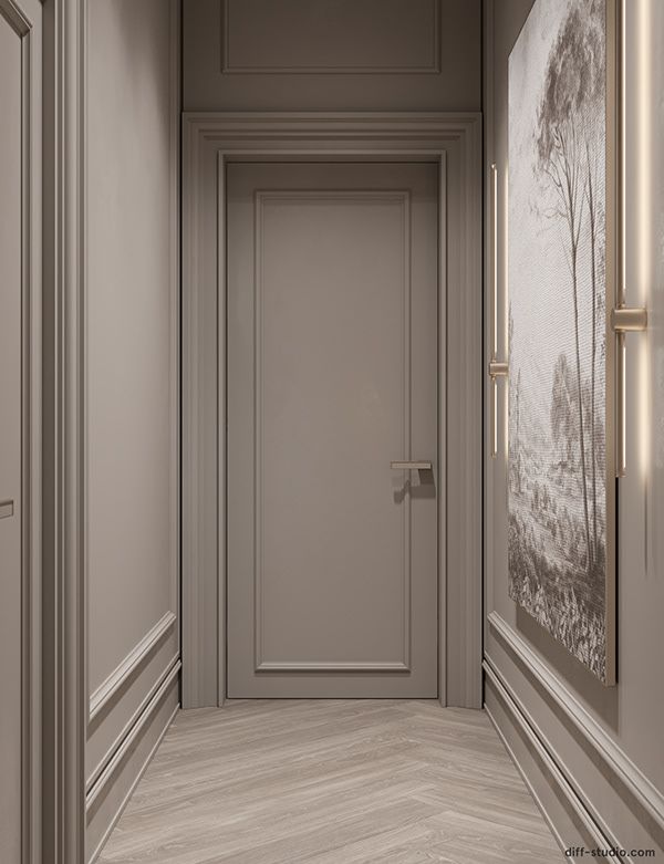 an empty hallway leading to a door with a painting on the wall and wooden floors