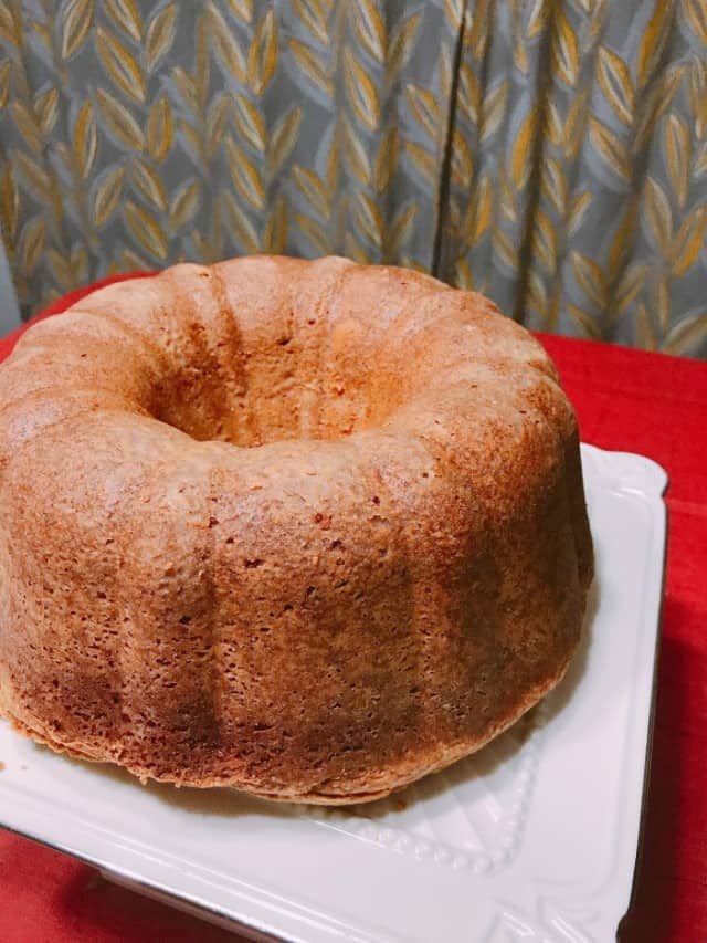 a bundt cake sitting on top of a white plate next to a red table cloth