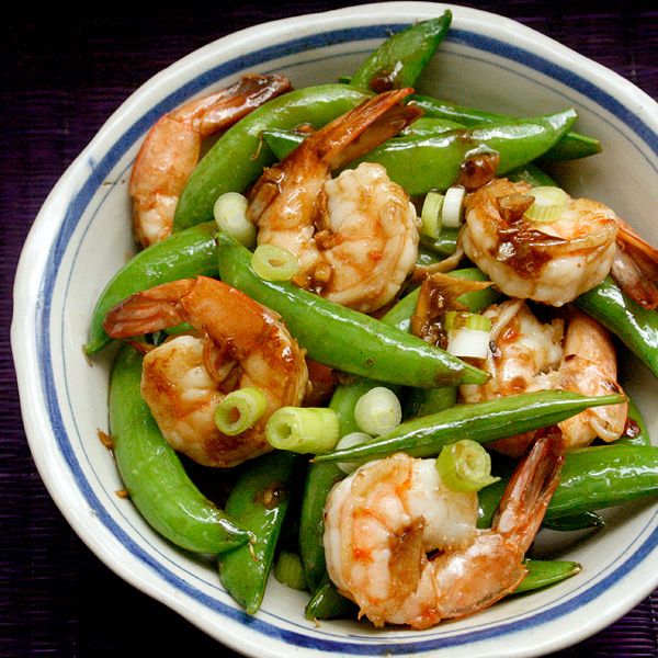 a white bowl filled with green beans and shrimp