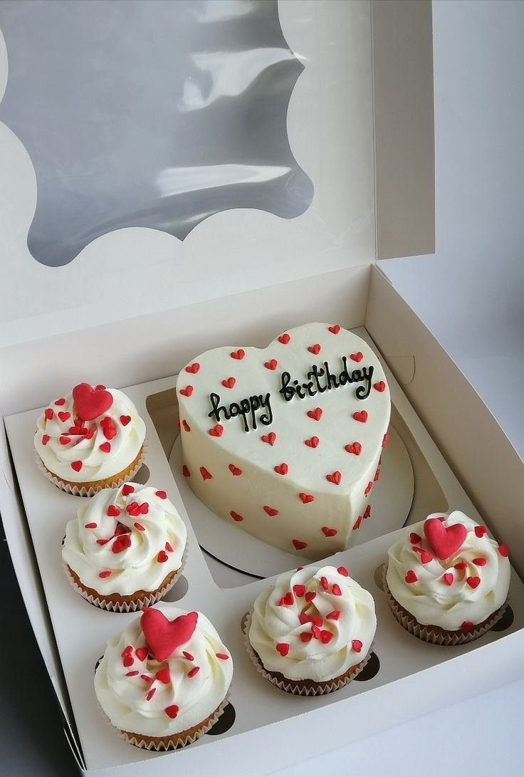 a heart shaped cake and six cupcakes in a box with the words happy birthday written on it