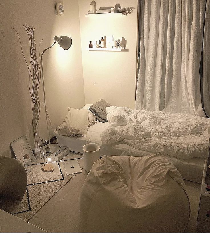 a bedroom with white sheets and pillows on the floor