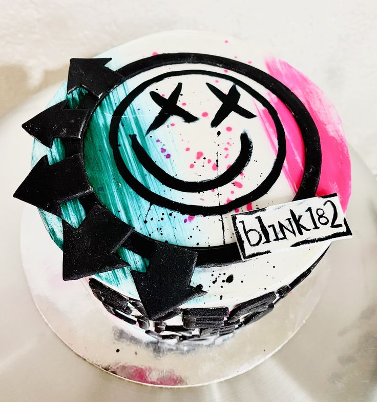 a white cake with black and pink designs on it's icing that says blinki - 12