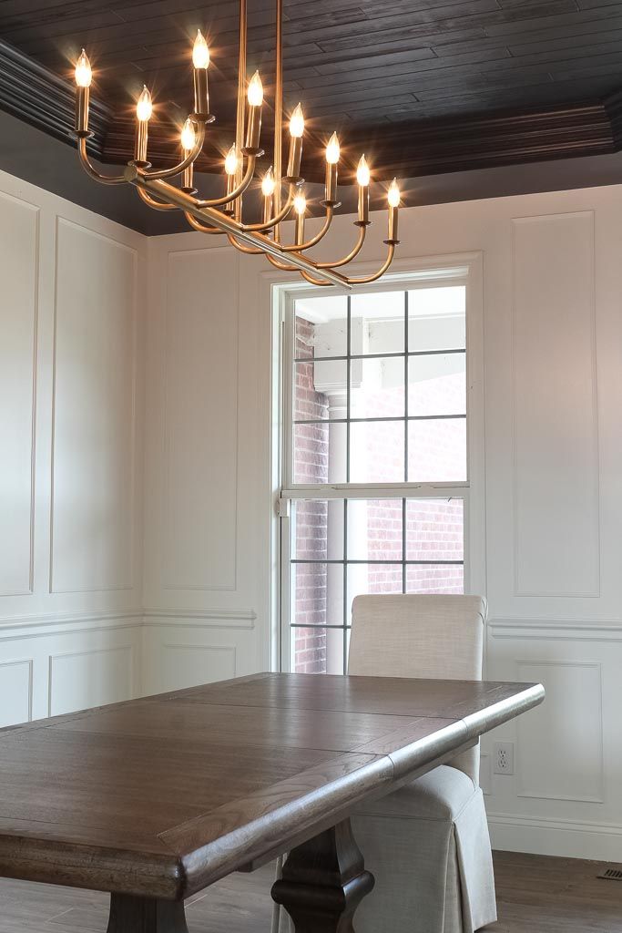 a dining room table with a chandelier hanging from the ceiling