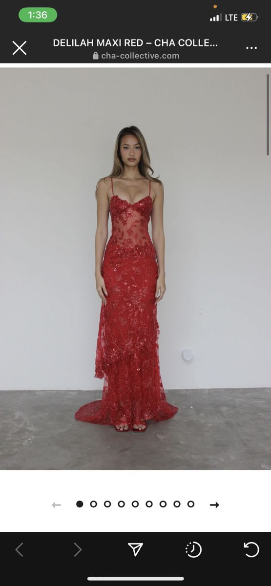 a woman in a red dress standing next to a white wall