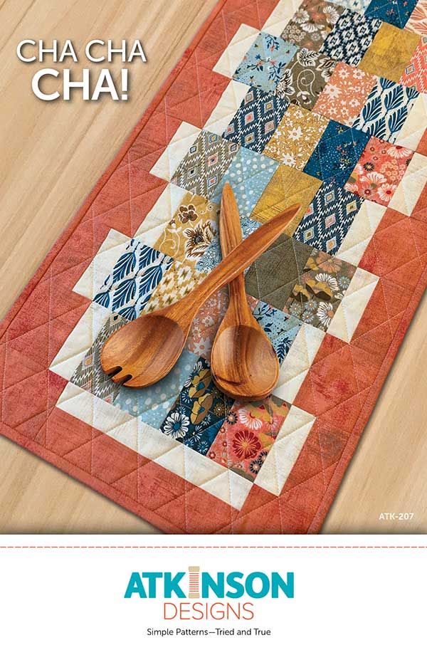 a table runner with wooden spoons on it and the words, cha cha cha