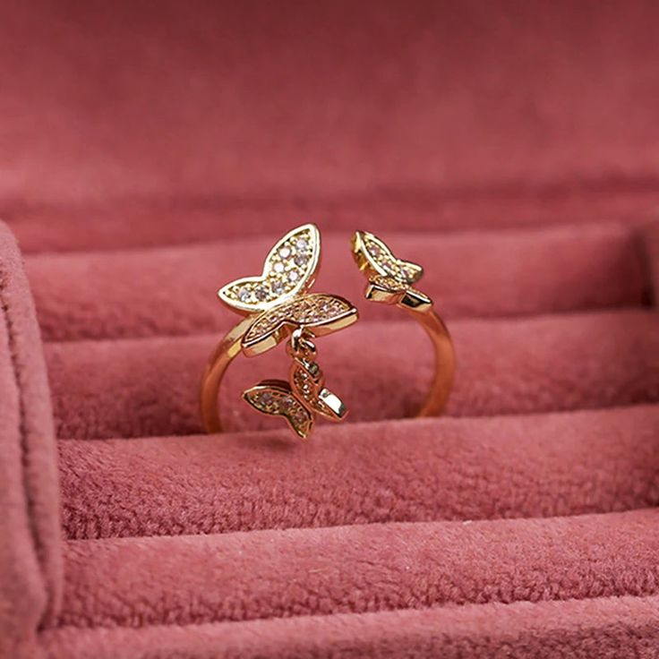 PRODUCT DETAILS: Introducing our new gold adjustable Butterfly Ring, a delightful accessory that captures the whimsy of fluttering butterflies. This charming ring features a playful butterfly design and an adjustable band for the perfect fit. It's a cute and stylish way to add a touch of fun to any outfit! Item Type: Ring Material: Gold-Plated Brass Size: Adjustable Gold Rings Butterfly, Butterfly Ring Jewelry Gold, Fine Jewelry Necklace Gold, Elegant Adjustable Metal Butterfly Ring, Adjustable Yellow Gold Butterfly Ring, Adjustable Gold-colored Sterling Silver Butterfly Ring, Gold Ring Designs, Butterfly Ring, Butterfly Drawing