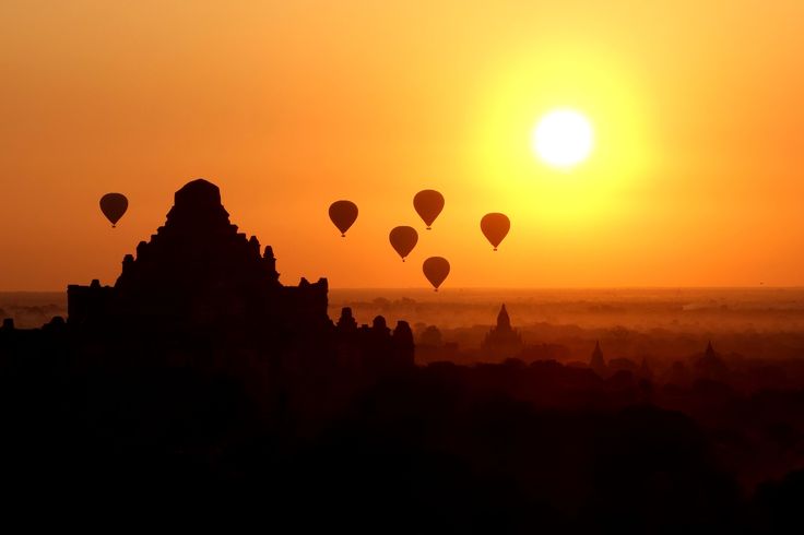 many hot air balloons flying in the sky