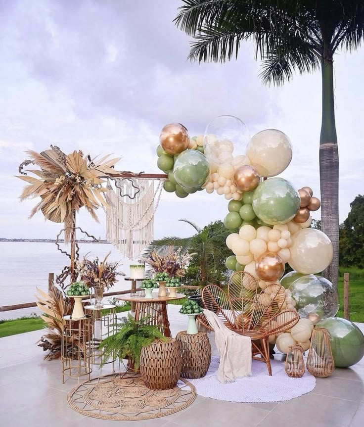 an outdoor party with balloons and decorations on the table, near the water's edge