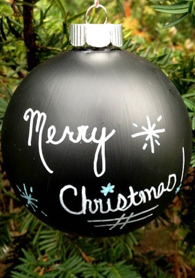 a black christmas ornament hanging from a tree