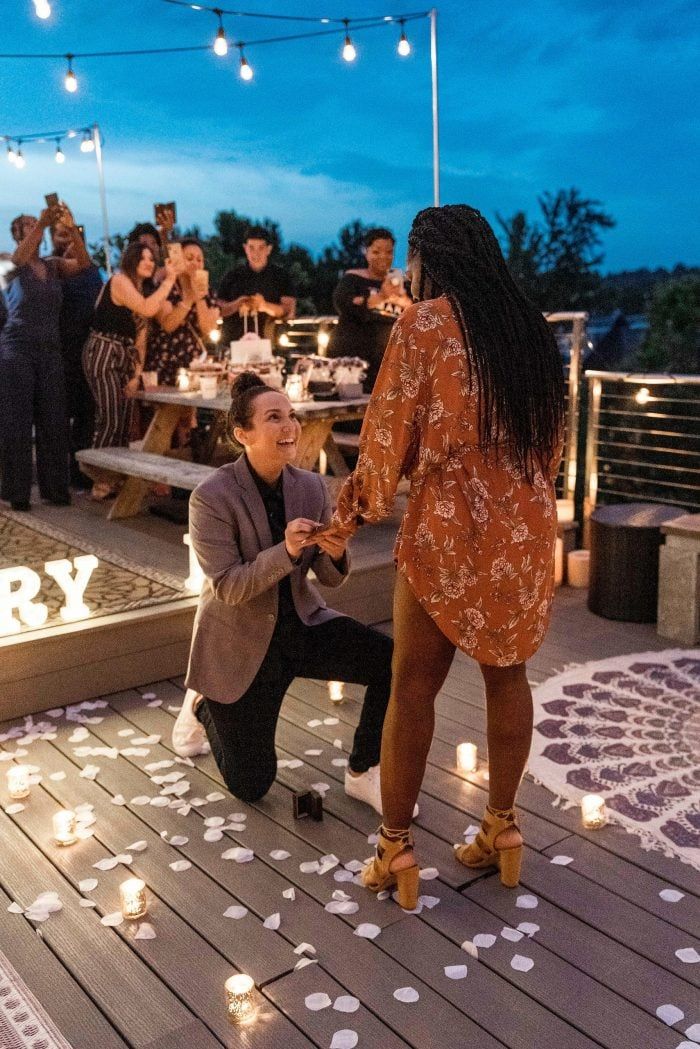 two women are dancing on a deck with candles