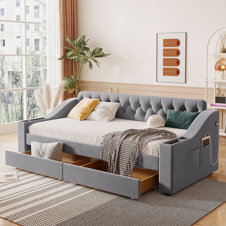 a day bed with drawers underneath it in a room next to a rug and window