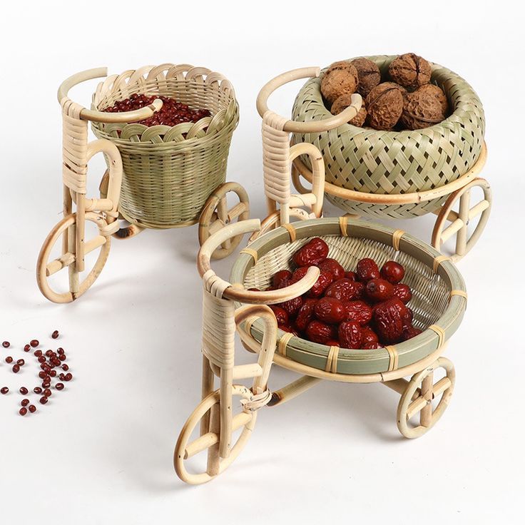 three wicker baskets filled with cherries and nuts, one on a wheelbarrow