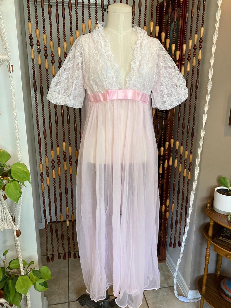 Glamorous 1950's/1960's peignoir dressing gown in pink and white. Attaches in middle with snaps behind bow. There are two tiny holes (pictured), no stains. Beautiful flowy nylon and lace. Vintage size medium. Based on measurements this is a modern size 6-10, and is photographed on a modern size 8 dress form. Please see measurements below: Bust 40 inches  Waist 34 inches  Hips free  Length 52 inches Spring Wedding Coquette Sleepwear, Sheer Fitted Party Robe, Vintage V-neck Wedding Sleepwear, Spring Party Lace Nightgown, Fitted Feminine Robe For Loungewear, Feminine Fitted Robe For Loungewear, Fitted Lace Robe For Loungewear, Vintage Sheer Pink Nightgown, Vintage Pink Sheer Nightgown