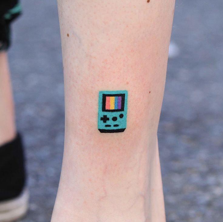 a person with a tattoo on their foot has a gameboy sticker on it