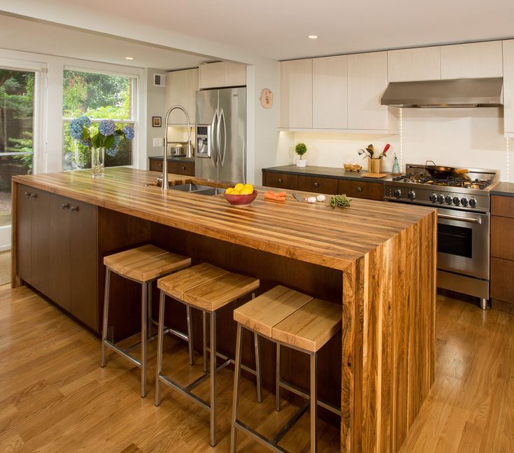 a kitchen island with stools in front of it