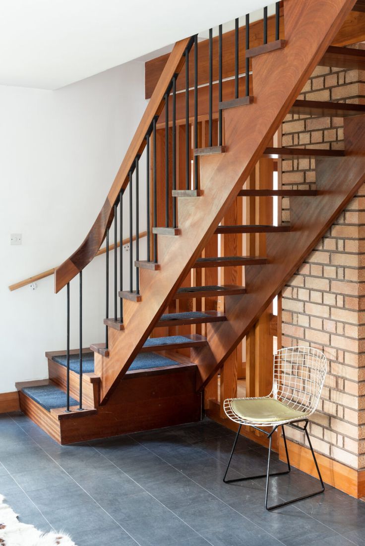 a chair sitting in front of a wooden stair case