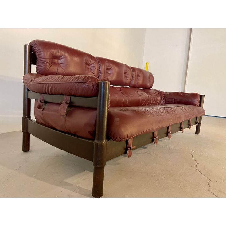 a brown leather couch sitting on top of a wooden frame