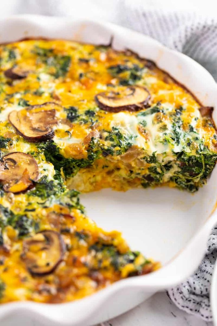 a casserole with cheese and spinach is cut in half on a plate