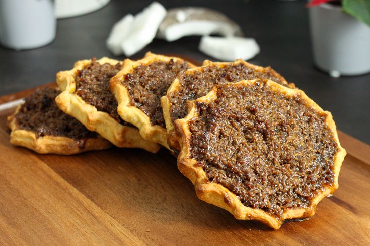 three pastries sitting on top of a wooden cutting board