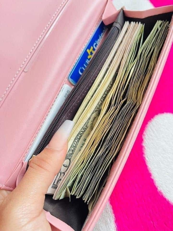 a pink purse filled with lots of money