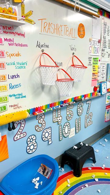 a classroom wall decorated with sports themed writing and numbers on the board, as well as basketball hoops