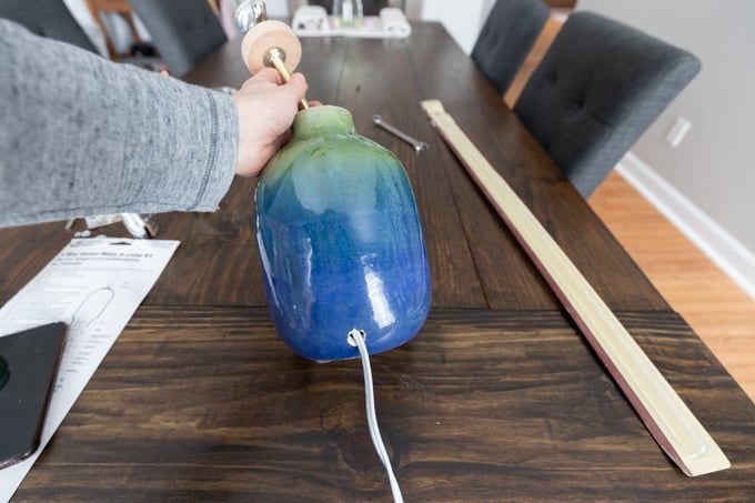 a table with a blue and green vase sitting on top of it