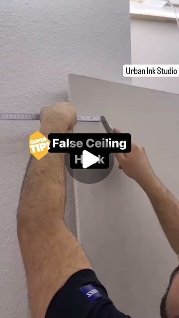 a man working on an unfinished wall with the words false ceiling