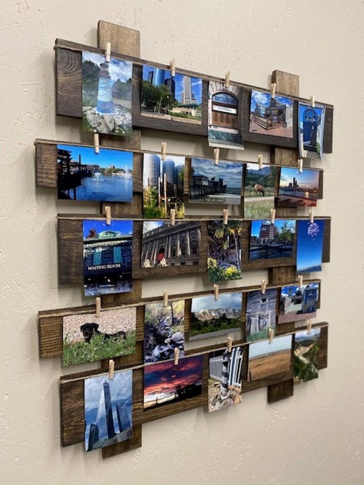 there are many pictures hanging on the wall with clothes pins attached to them and pinned to wood planks