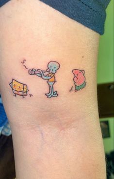 a person with a small tattoo on their arm that has an image of a cartoon character