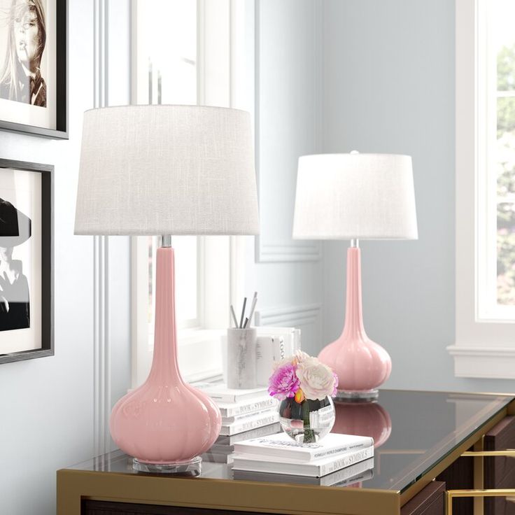 two pink lamps sitting on top of a table