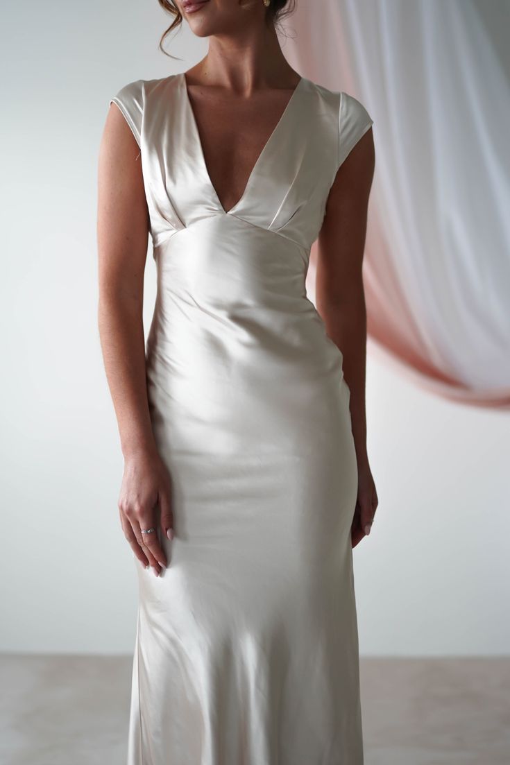 a woman in a white dress posing for the camera