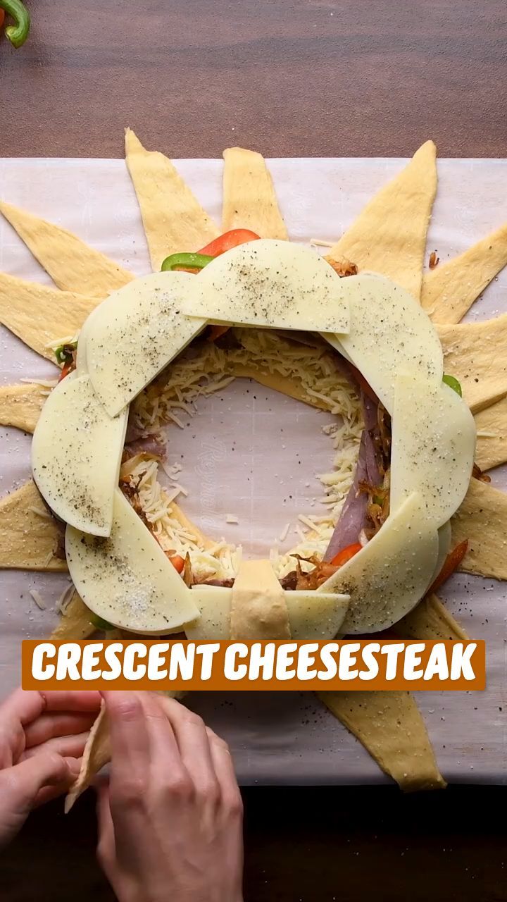 someone is making a cheesesteak wreath out of bread