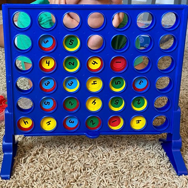 a child playing with a giant connect game