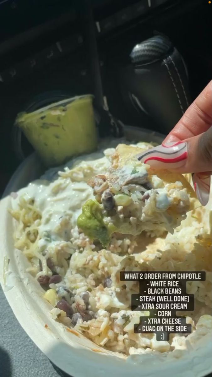 a person is holding a fork over a plate of food