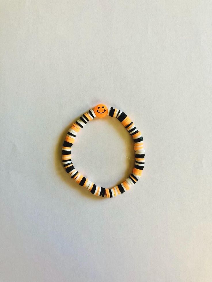 Clay beads in Halloween colors with orange smiley. Playful Orange Beaded Bracelets With Letter Beads, Playful Black Beaded Bracelets With Letter Beads, Fun Handmade Black Beaded Bracelets, Handmade Fun Black Beaded Bracelets, Casual Orange Stretch Bracelet With Letter Beads, Playful Orange Bracelets With Colorful Beads, Fun Black Beaded Bracelets With Round Beads, Trendy Orange Beaded Bracelets With Letter Beads, Playful Handmade Black Bracelets