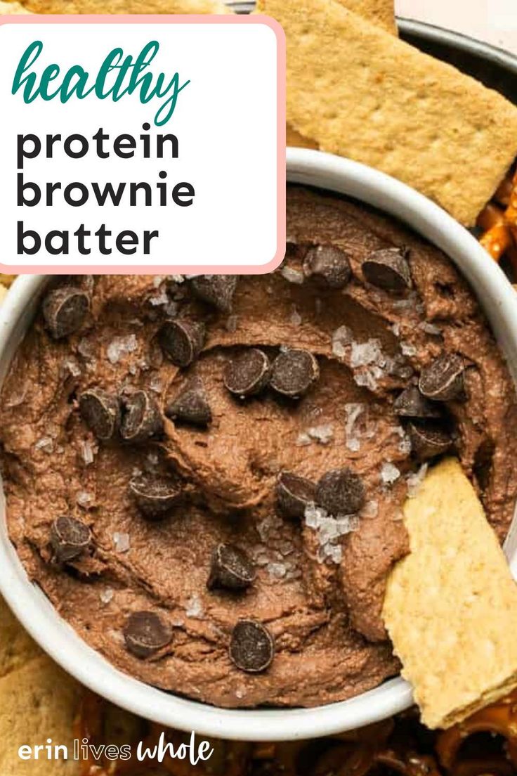 a bowl filled with chocolate protein brownie batter and crackers on the side, next to some tortilla chips