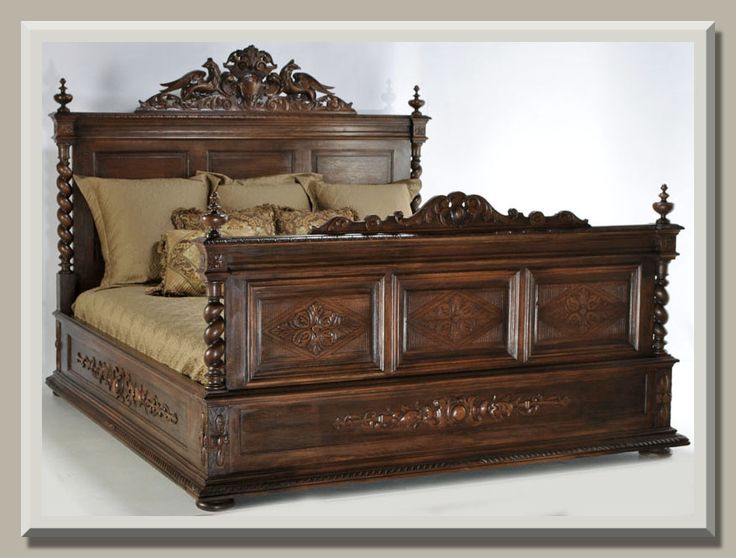 a large wooden bed with intricate carvings on the headboard and foot board