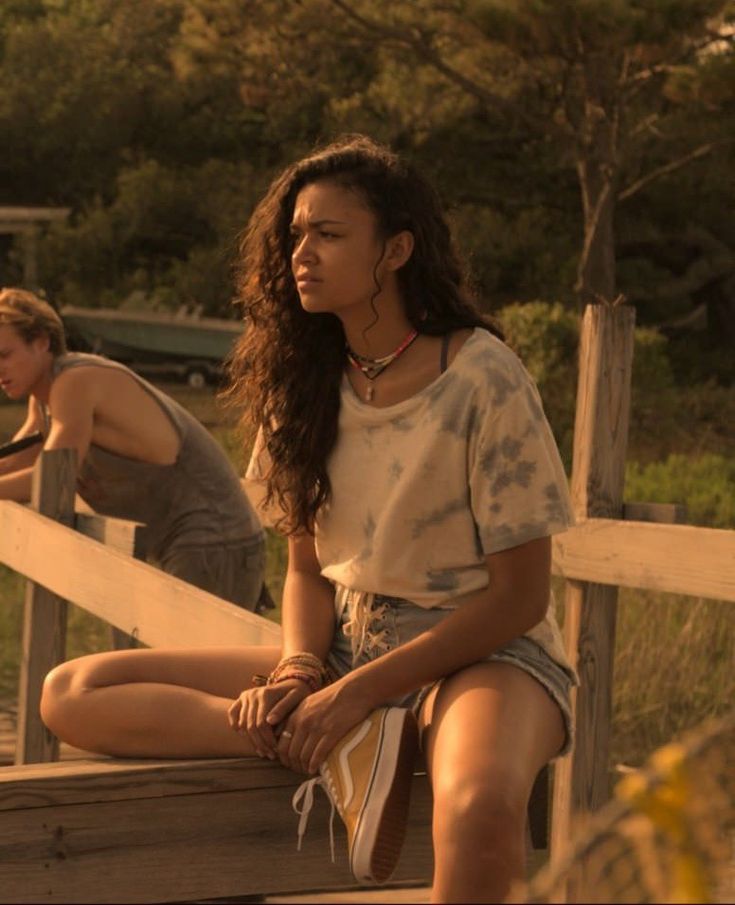 two young women sitting on a wooden porch