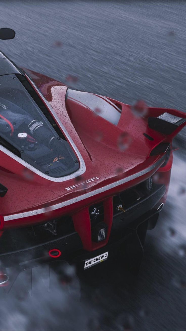 a red sports car driving on the road in the rain with its hood up and windshield down