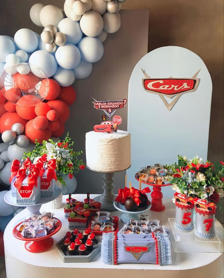 the dessert table is decorated with red, white and blue balloons for cars themed birthday party