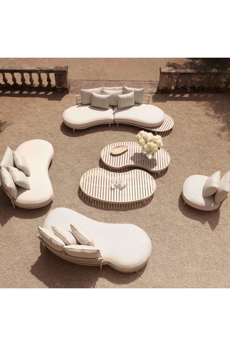 a group of white lounge chairs sitting on top of a cement ground