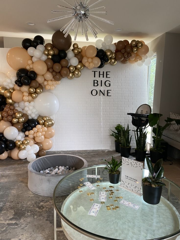 the big one balloon wall is decorated with balloons and greenery in black, white, gold and silver colors